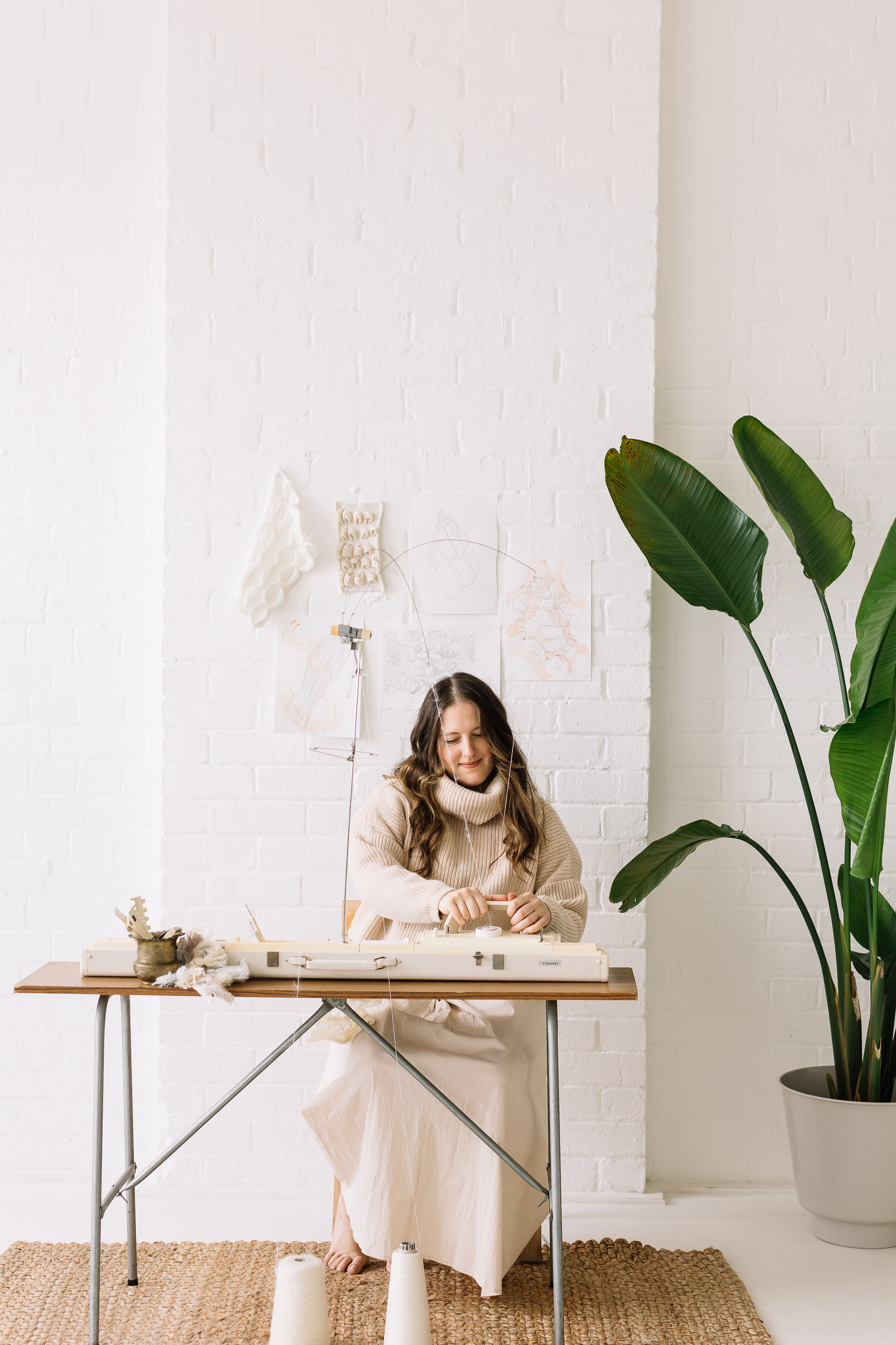 Amber sitting at a knitting machine