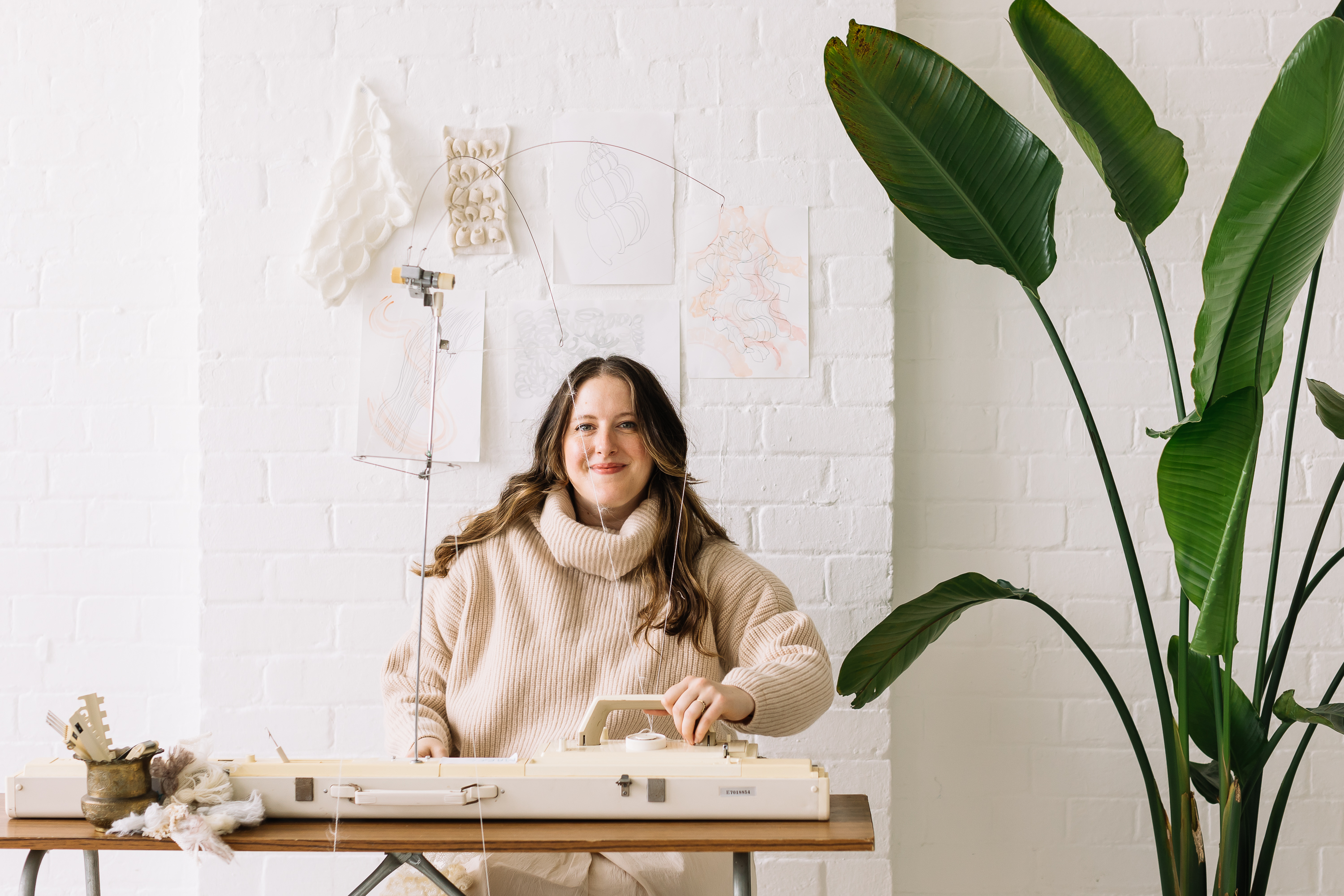 Amber sitting at a knitting machine